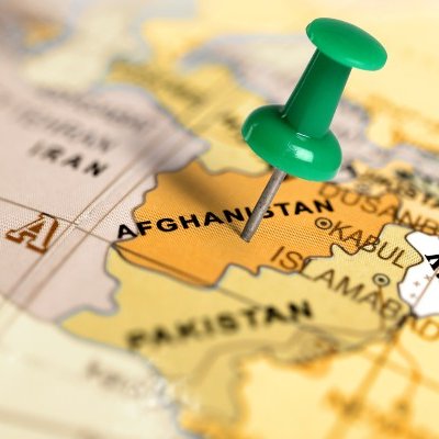 Thumbtack stuck on Afghanistan on world map.